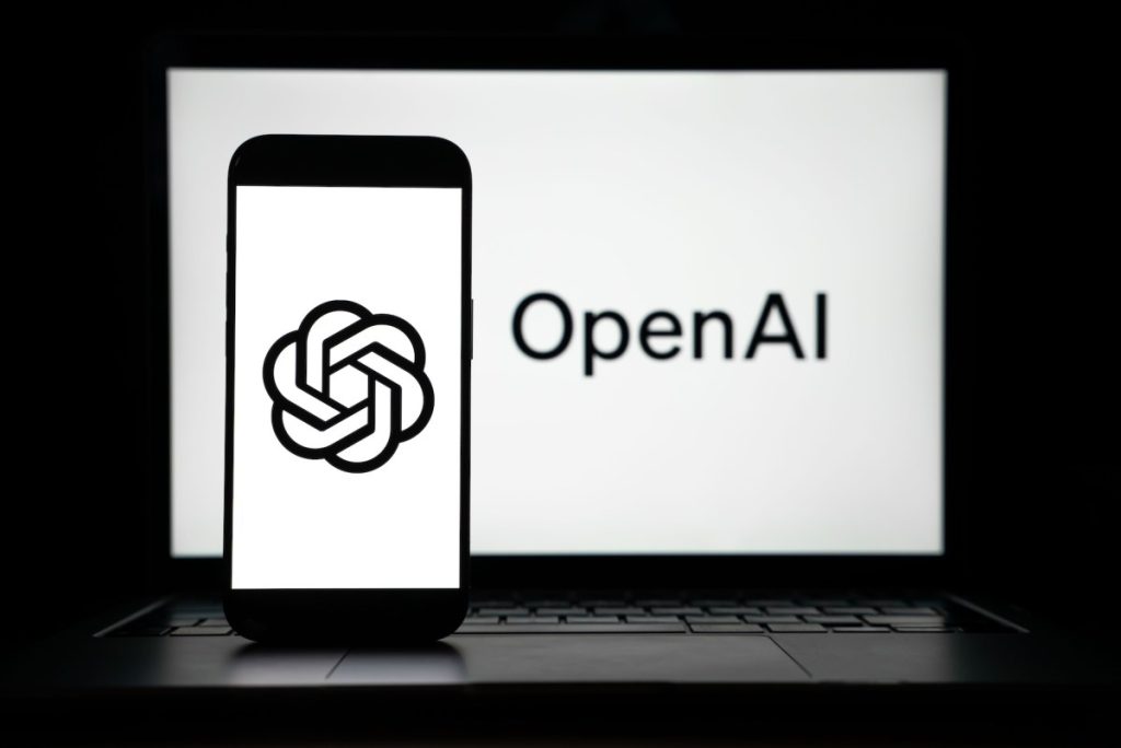 the logos of Open AI displayed on both computer and smart phone screen
