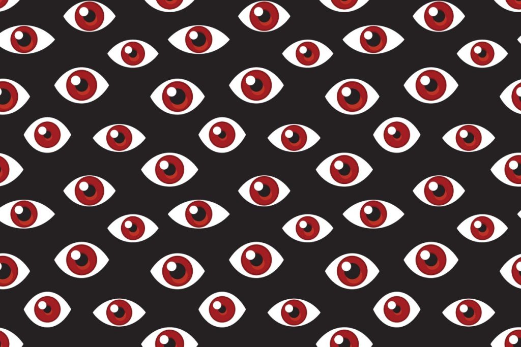 a pattern of red eyes on a darkened background