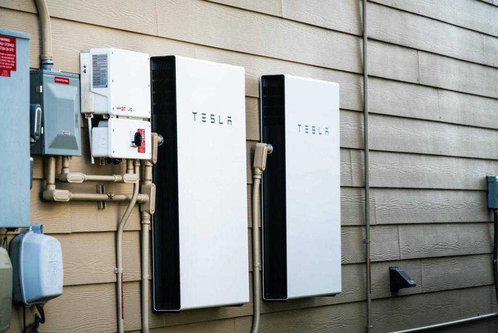 Two Tesla Powerwalls sit on the outside of a house.