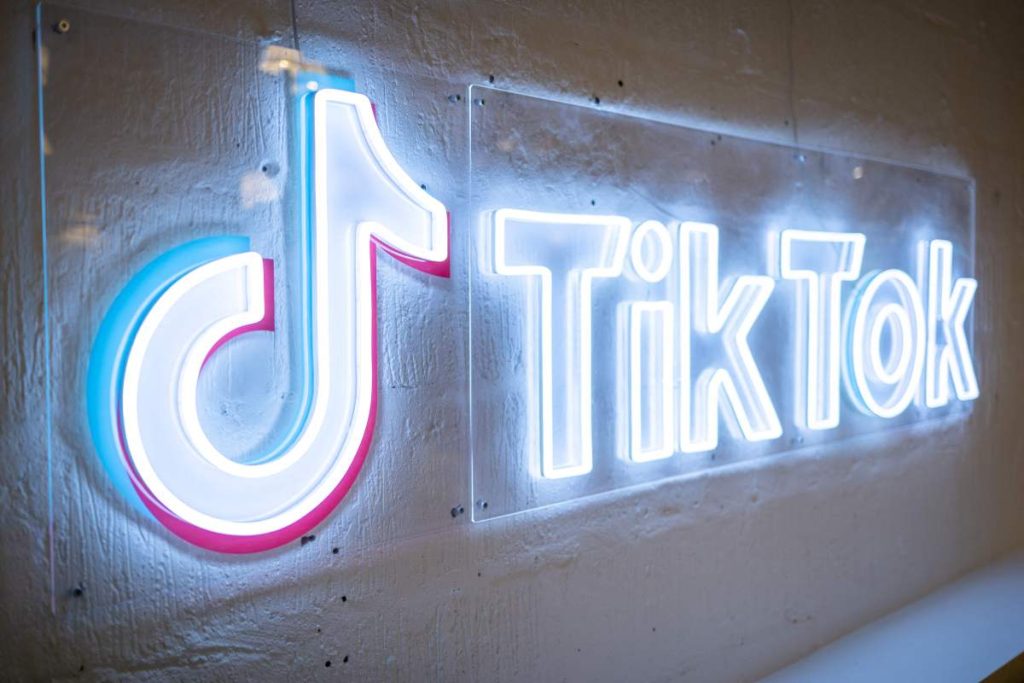 Cameo partners with TikTok to boost popularity TikTok's neon logo and music note symbol on a concrete wall