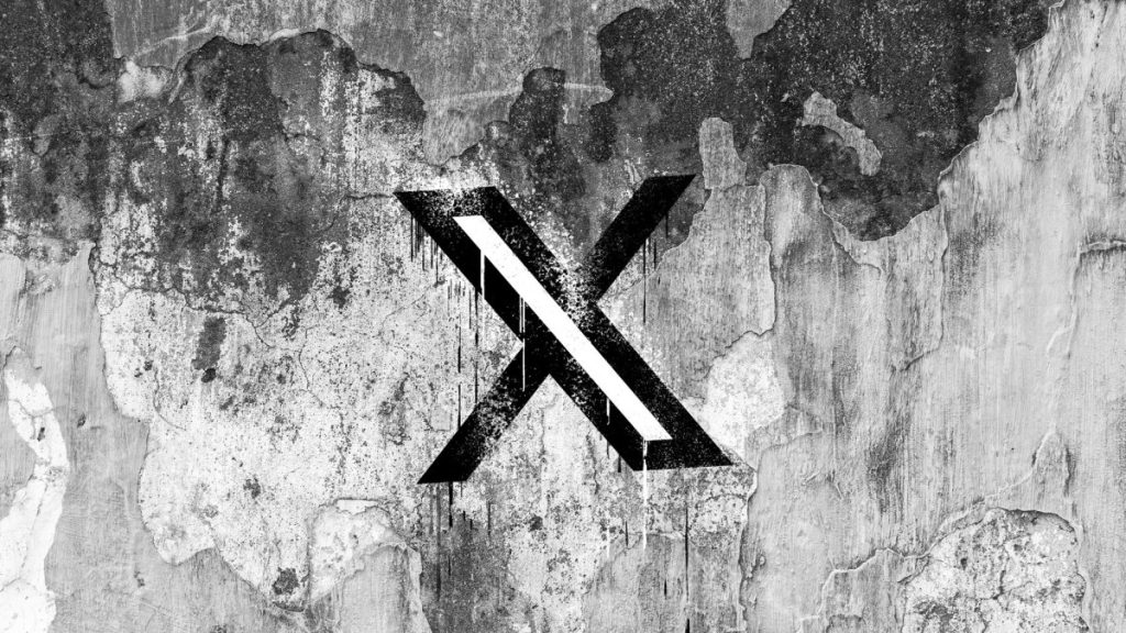 X is rolling out automatic translation and photo editing powered by Grok X (formerly Twitter) logo on a cracked wall