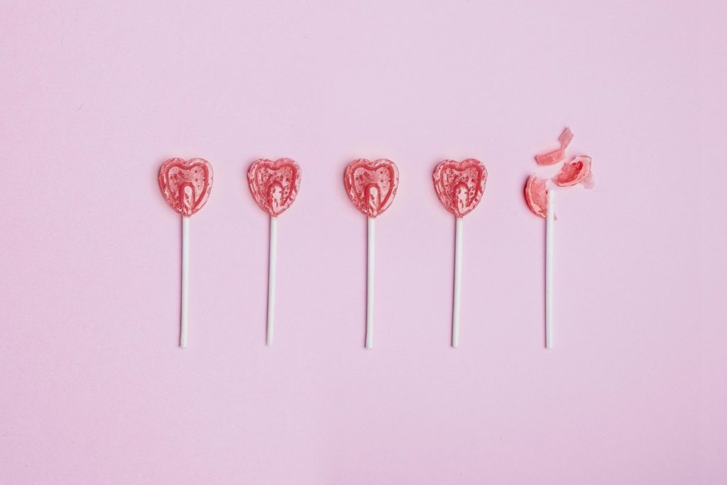 Almost half of U.S. singles feel negatively about AI in dating, Match says Five lollipop hearts on a pink floor, but the last one is smashed to pieces.