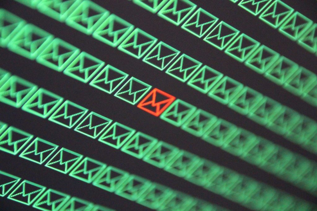 red email envelope in a sea of green email envelopes