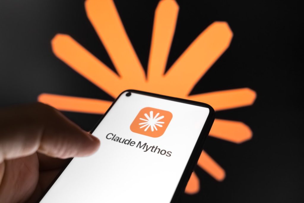 Cybersecurity vets protest ‘dangerous’ US government ban on Anthropic’s most powerful models The Claude Mythos logo appears on a smartphone screen, and the Claude AI logo displays as the background on a laptop computer screen.