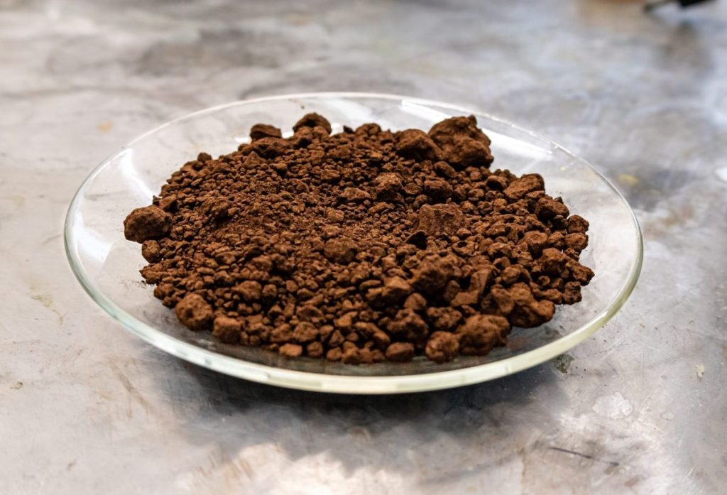 Fast Metals is treating waste with more waste to extract critical minerals A plate of red mud sits on a lab workbench.