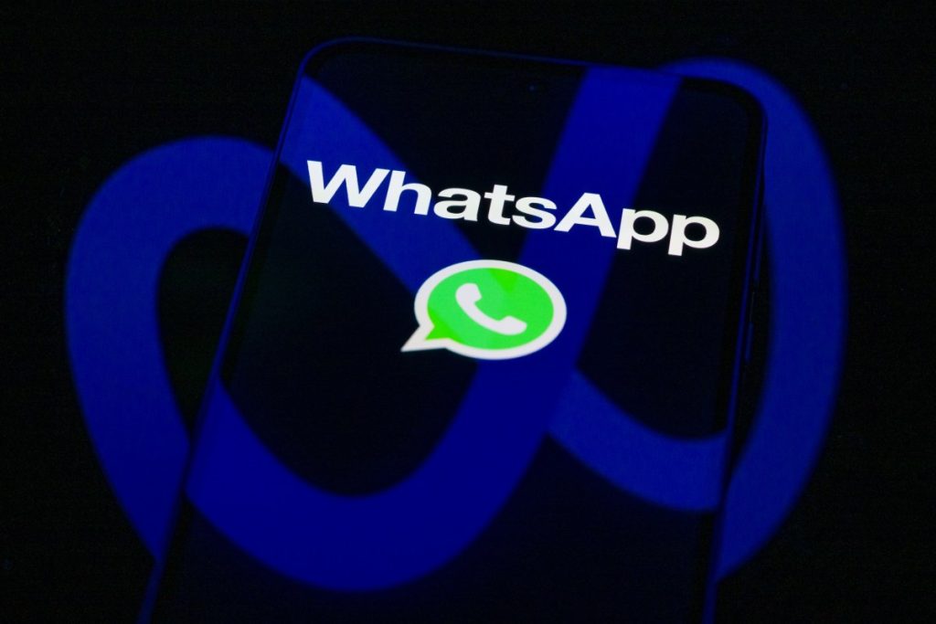 The WhatsApp logo is displayed on a mobile phone screen in this photo illustration.